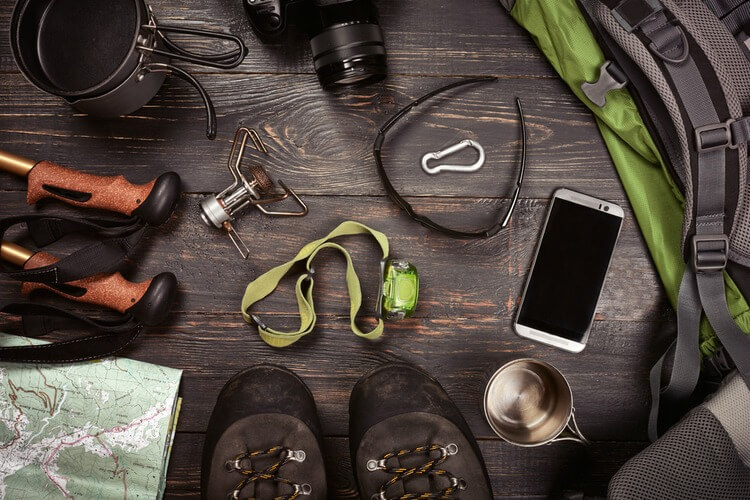 Hiking equipment lying on dark wood background