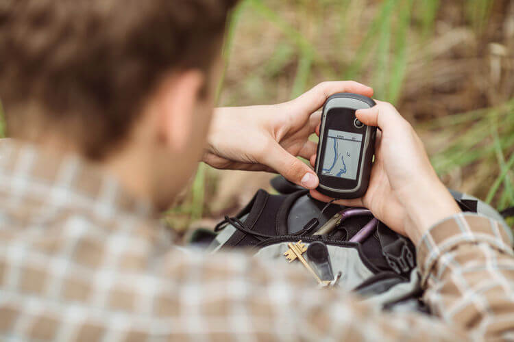 Man in woods using GPS tracker