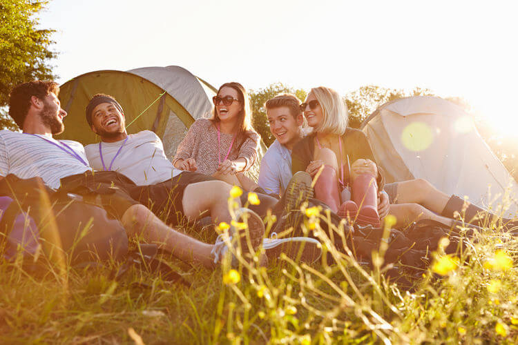 Group of people relaxing at a campsite with tents