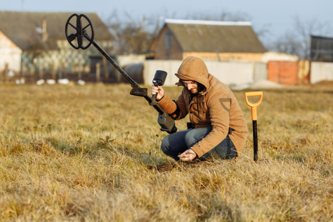 Man metal detecting in a field