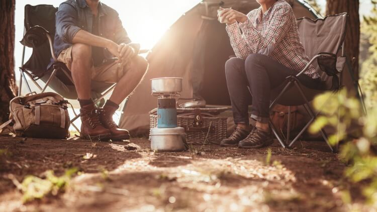 Two people camping with a camping stove