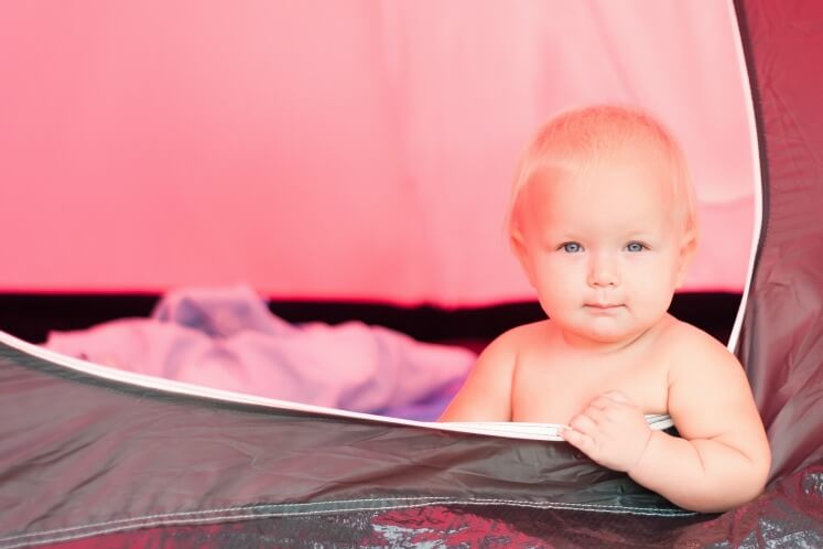 Baby sitting in a tent